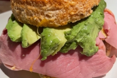 Round Croissant sandwich with egg, cheese, ham, & avocado